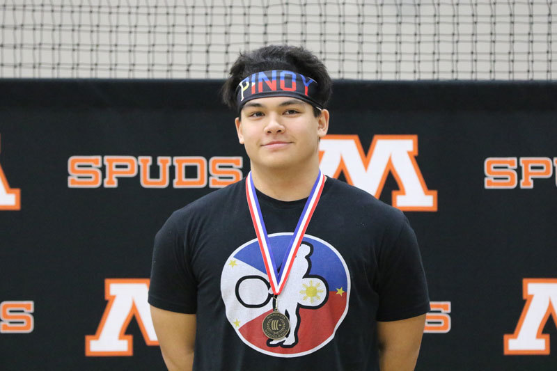 Chrisanto D'Agostino is photographed with his USA Weightlifting National Junior Championship meal in front of the Moorhead Spuds logo. 