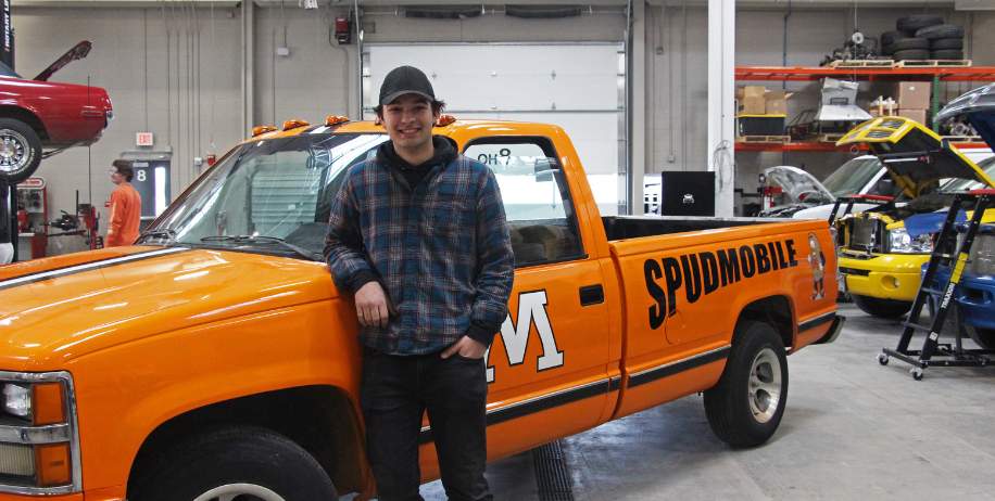 Senior Carter Norman stands next to new Spudmobile