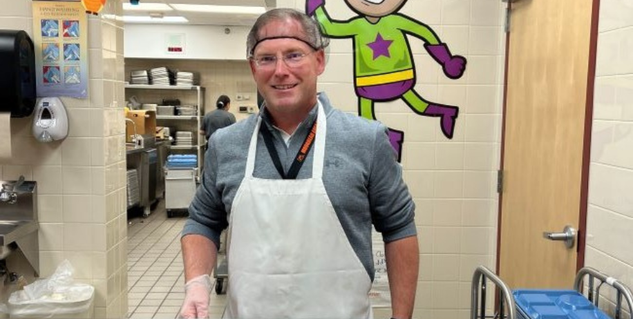 Superintendent Lunak geared up and served students their local meals. 