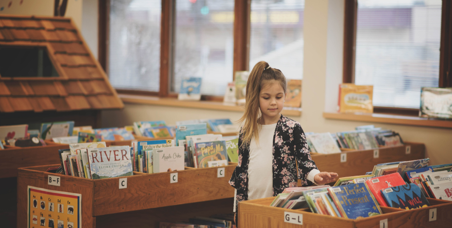 Little girl browsing books in the library