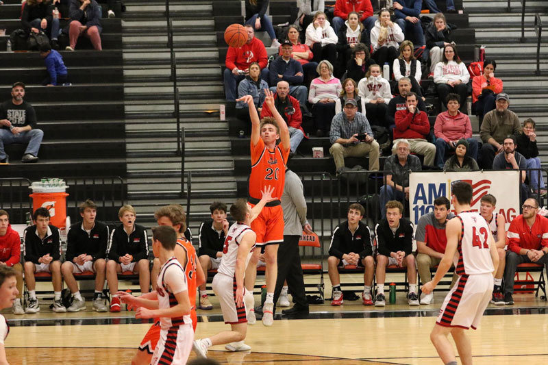 A picture of a Moorhead boys basketball player taking a jump shot from the 3 point line.