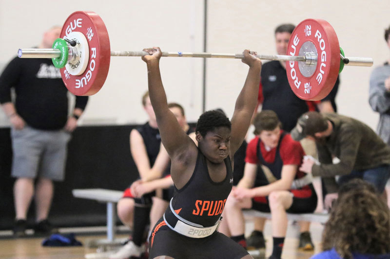 A picture of a weightlifter lifting a very heavy weight.