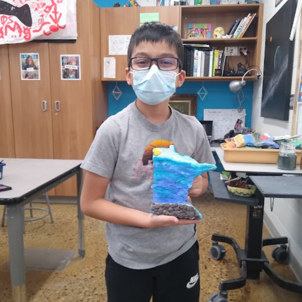 Student holding their project based on the Lakes of Minnesota