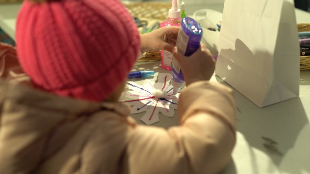 Child doing arts and crafts with a snowflake design