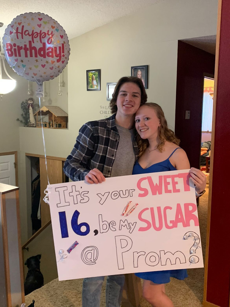 Students asks another student to prom with sign that says It's your sweet 16, be my sugar at prom
