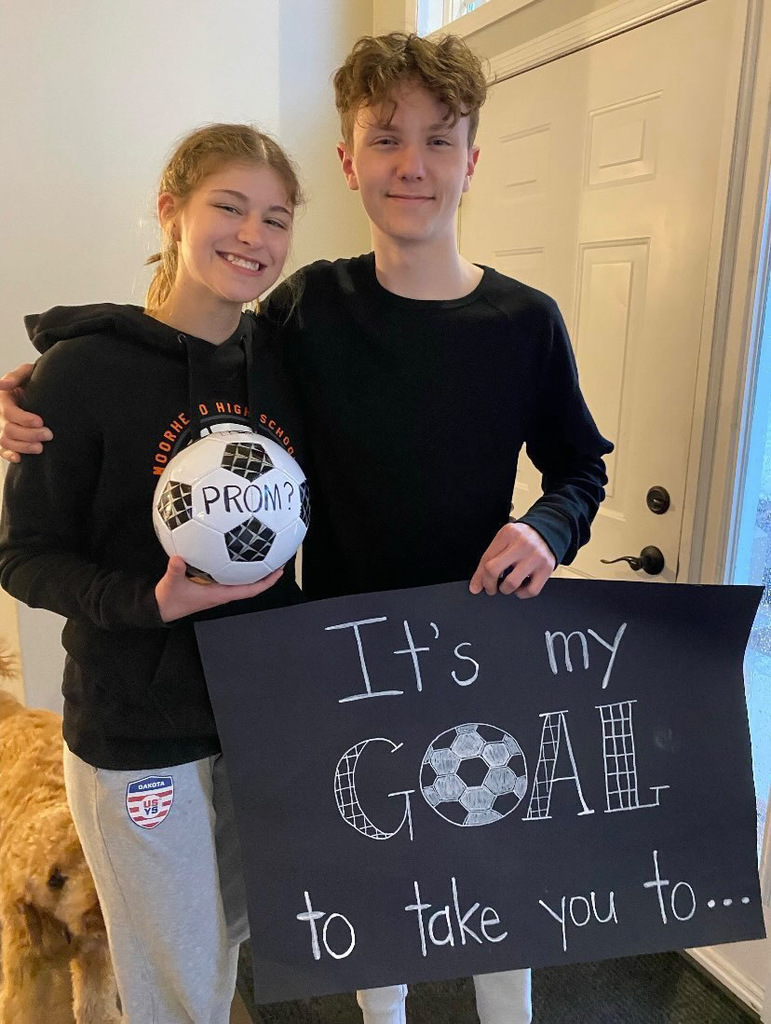 Students asks another student to prom with sign that says It's my goal to take you to prom