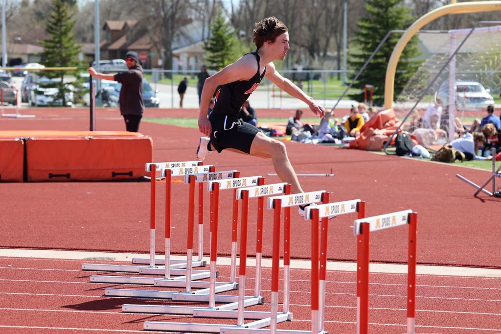 Student jumps over track hurdle