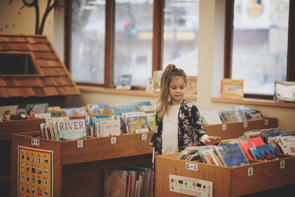 Girl looking at library books
