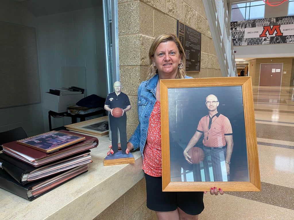 Sarah Strand, MHS class of 1980, holds photos of her father Shocky Strand