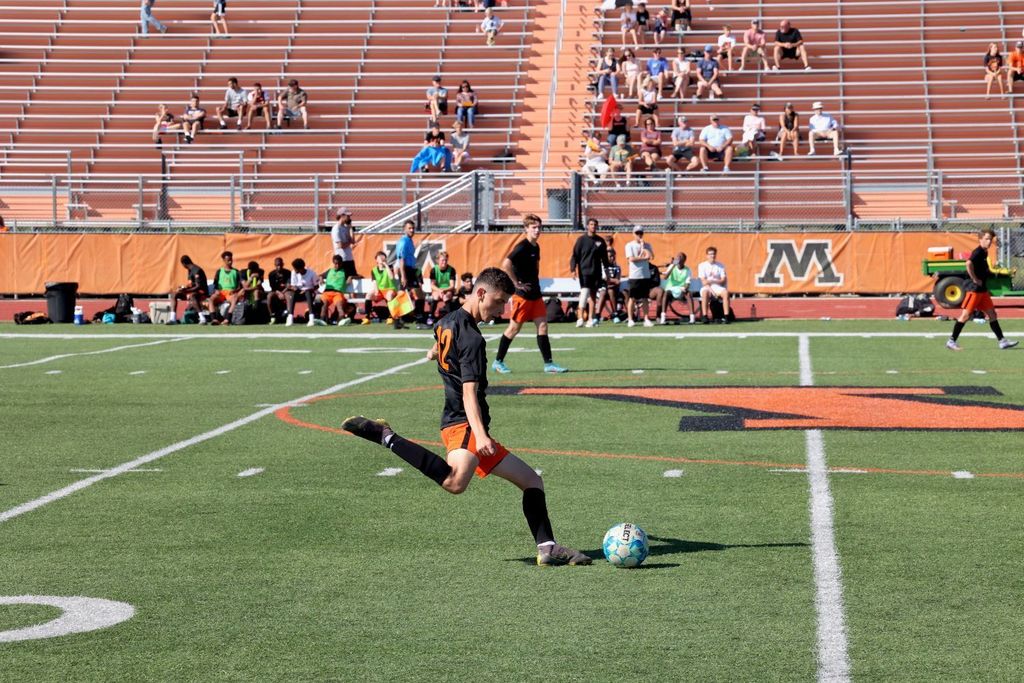 Student prepares to kick the soccer ball