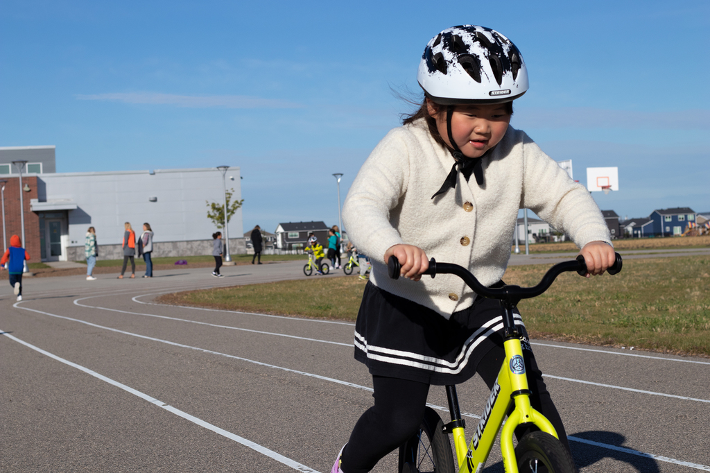 Student rides bike on elementary school track outside