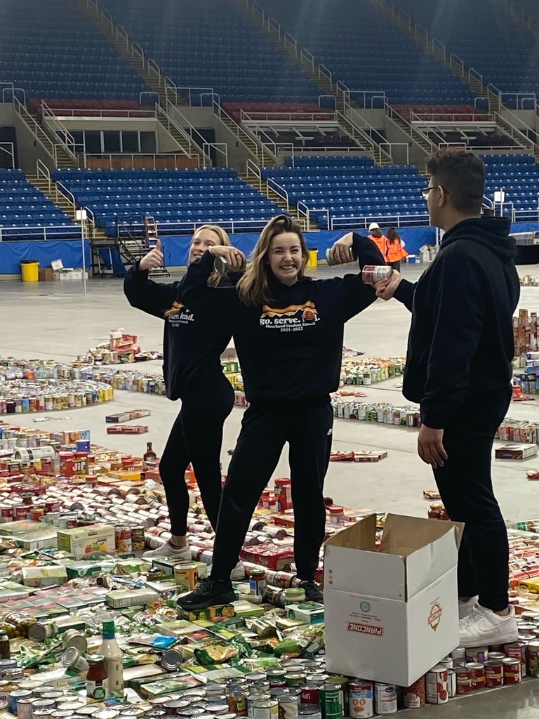 students hold up donated canned food items