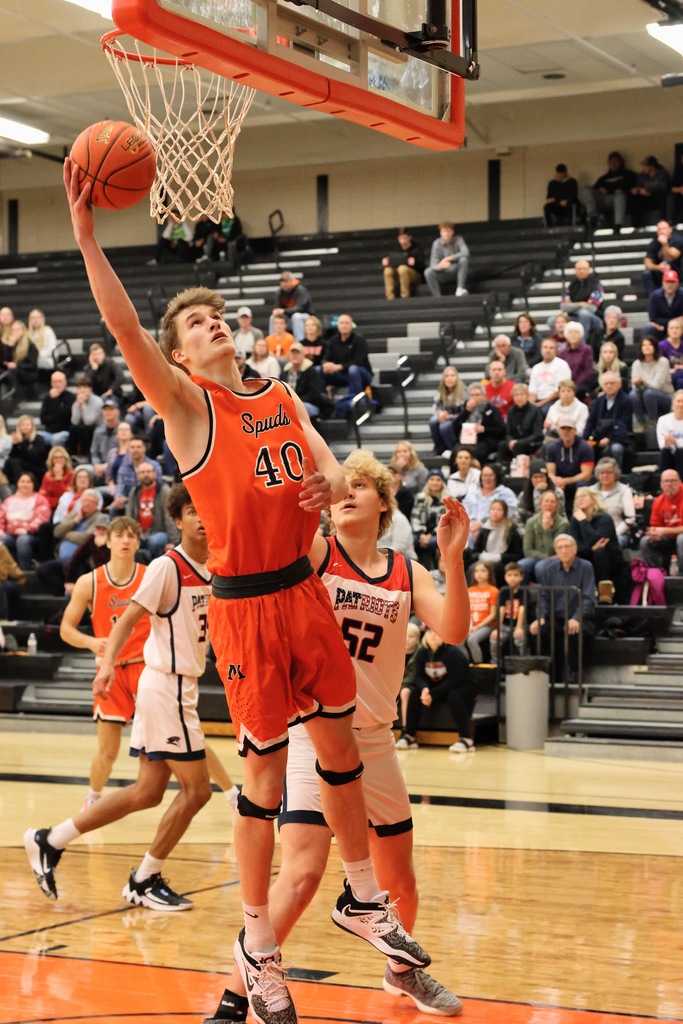 basketball player jumps for a shot on net