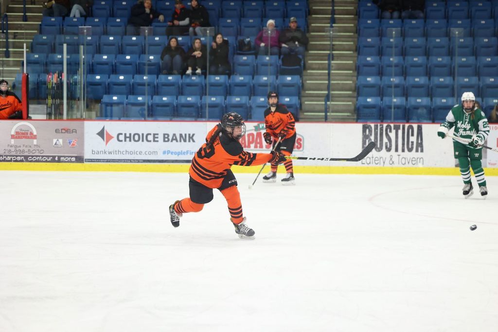 Girls Hockey, player hits the puck and scores.