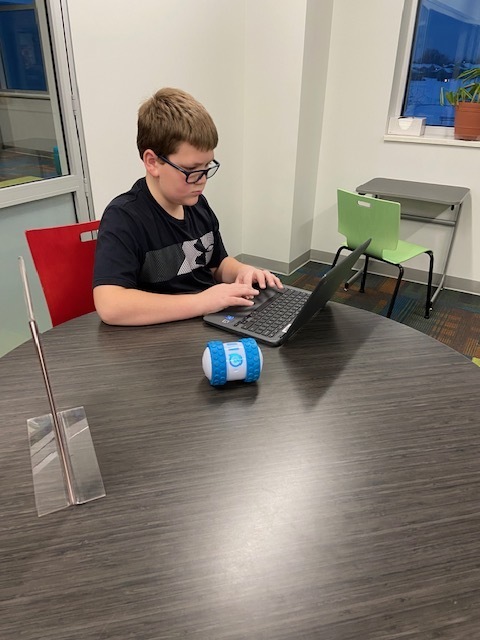 Student works on computer to code a machine