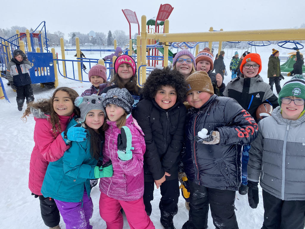 Students outside for recess stop for a picture