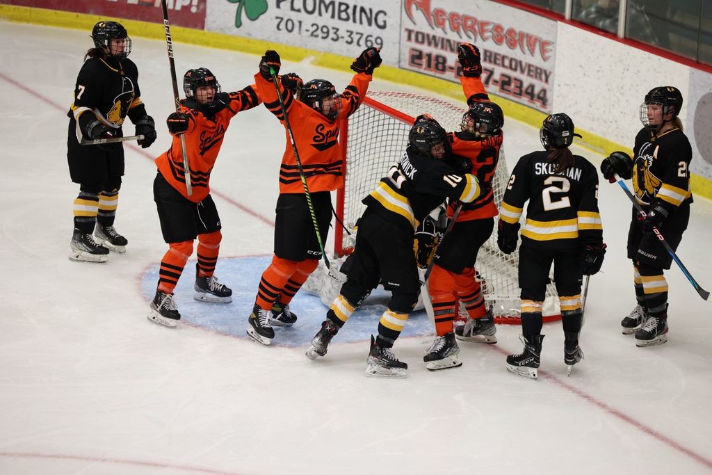 Girls hockey players celebrate a goal
