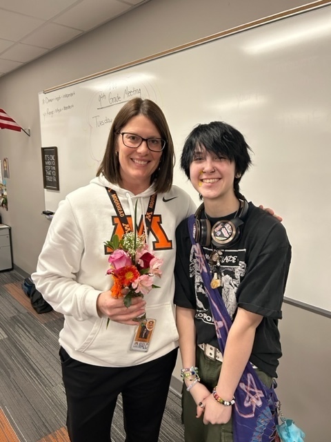 student and teacher pose for picture