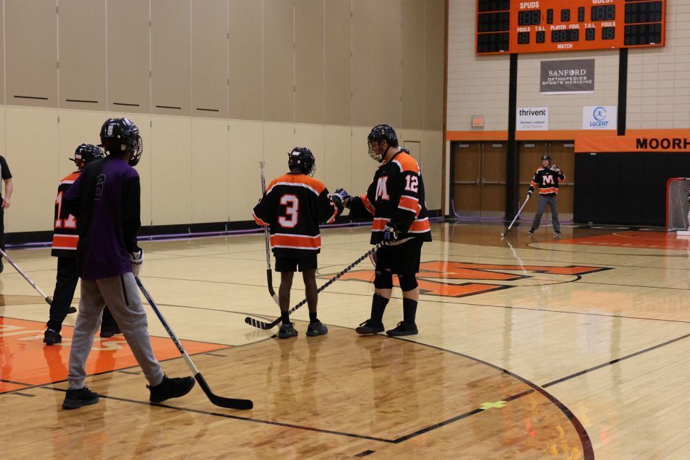 two students fist bump after a player ties the game with a goal