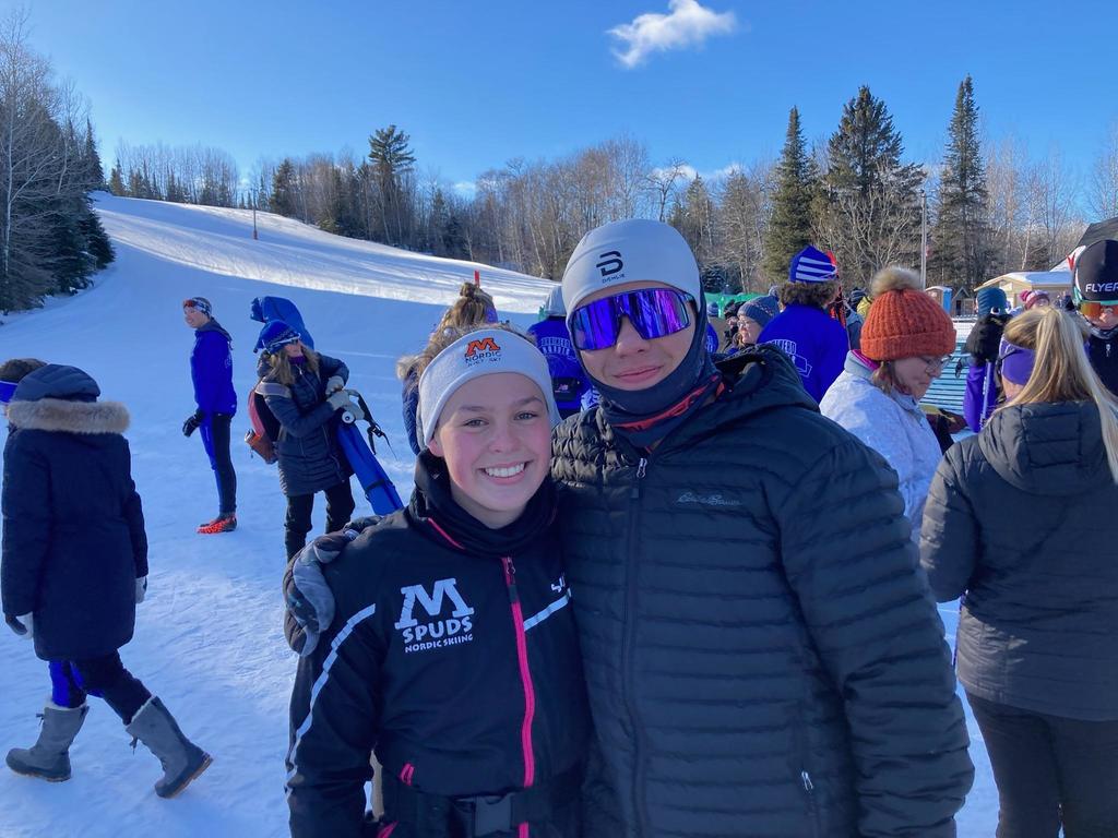 two nordic skier teammates pose for a picture